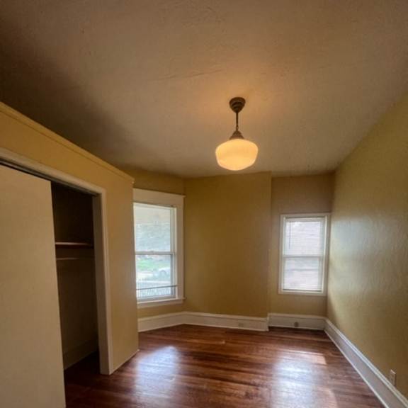 a small room with a window and a light on the wall.