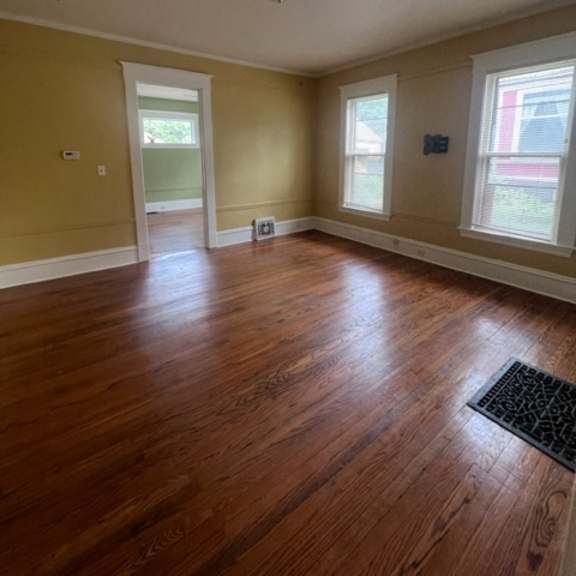 a room with wooden floors and skylights.