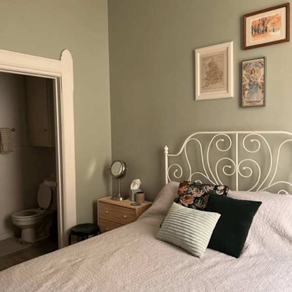 a bedroom with a bed, nightstand, and a mirror.