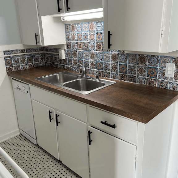 a kitchen with white cabinets and a tiled backsplash.
