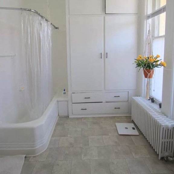 a bathroom with a tub, sink, and a window.