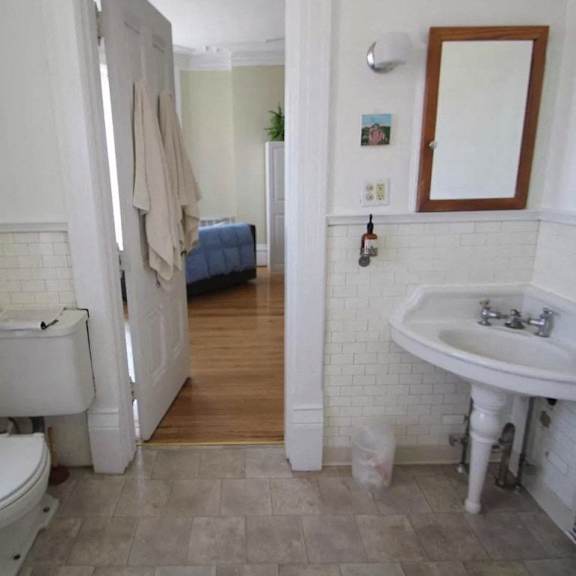 a white toilet is in a bathroom with a white sink and a white tub.