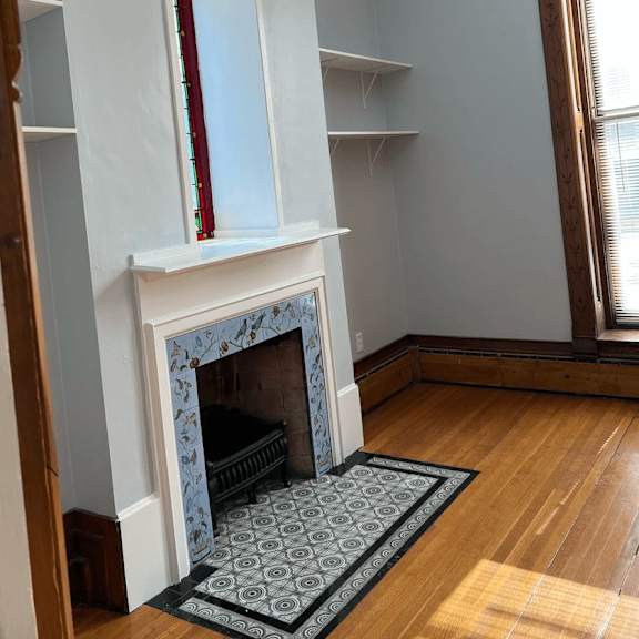 a fireplace with a red mantle and a black grate.