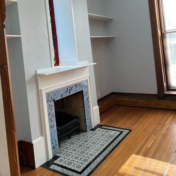 a fireplace with a red mantle and a black grate.