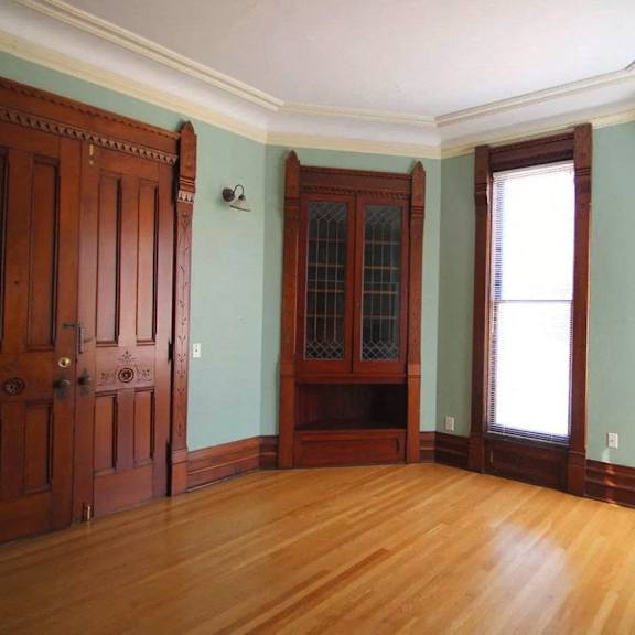 a room with a wooden floor and a large wooden door.