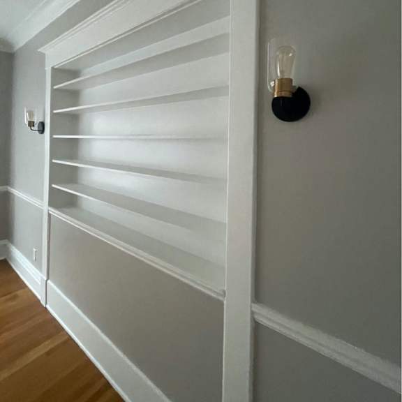 a white shutter is closed on a wall.