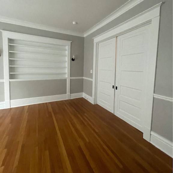 a room with a white door and a wooden floor.