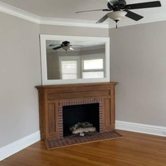 a room with a fireplace and a ceiling fan.