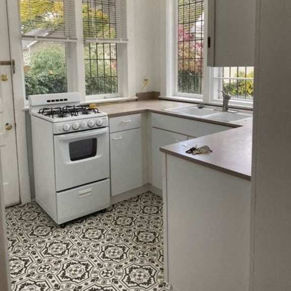 a white kitchen with a patterned floor.