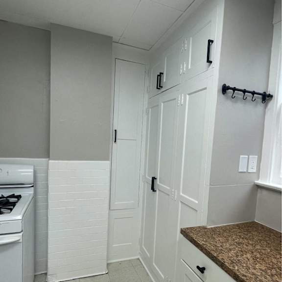 a kitchen with white cabinets and a stove top oven.