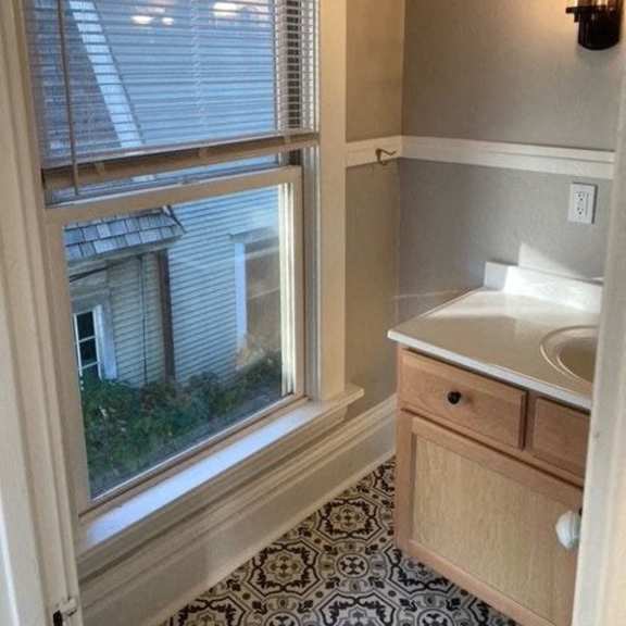 a bathroom with a window overlooking a house.
