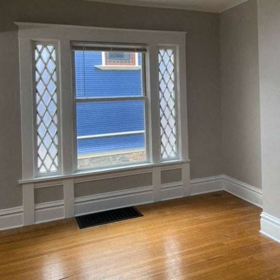 a room with a ceiling fan and a window with a view of a blue fence.