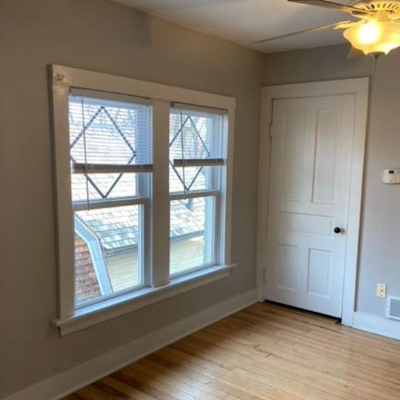 a room with a white door and a window with a view of a balcony.