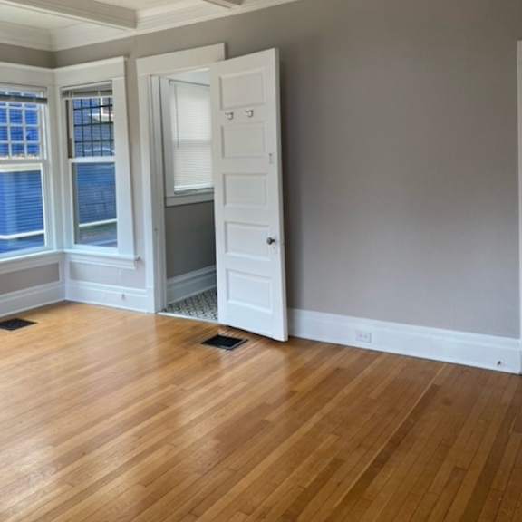 a room with a ceiling fan and a doorway leading to another room.