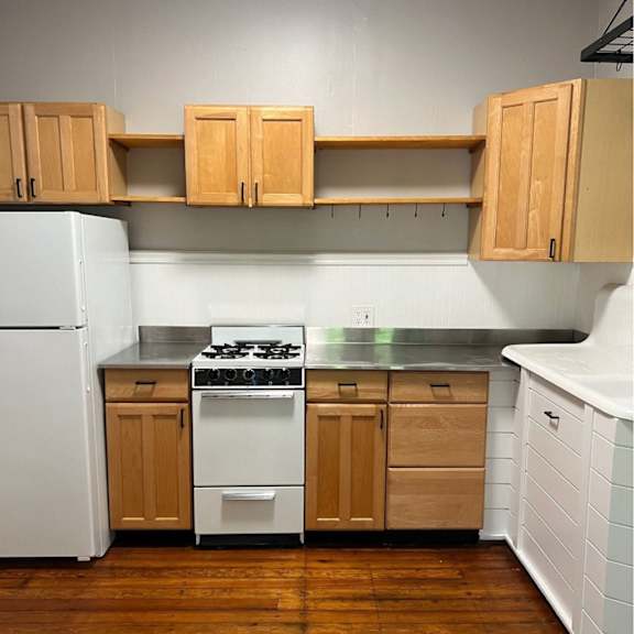 a kitchen with wooden cabinets and a white refrigerator.