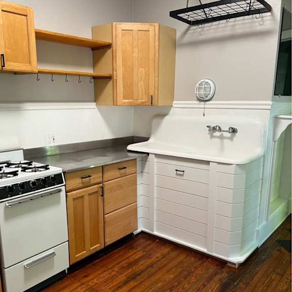 a kitchen with wooden floors and white appliances.