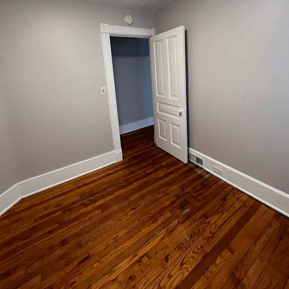a room with a wooden floor and a white door.