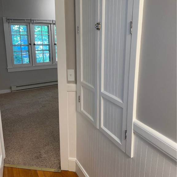 a white door with a silver handle is on the right side of the image.
