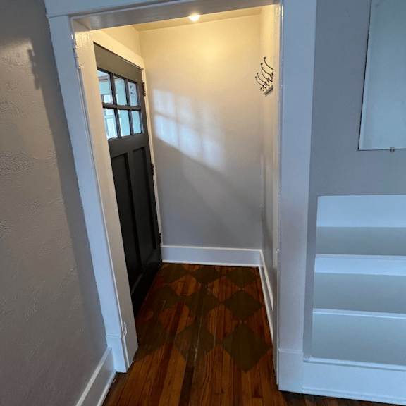 a hallway with a wooden floor and white walls.