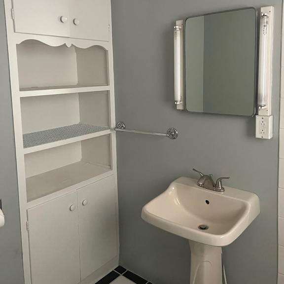 a white bathroom with a sink and a mirror.
