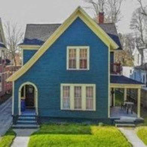 a blue house with a yellow roof and white trim.