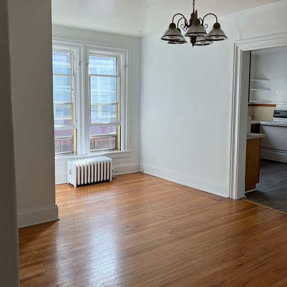 a room with a wooden floor and a chandelier.