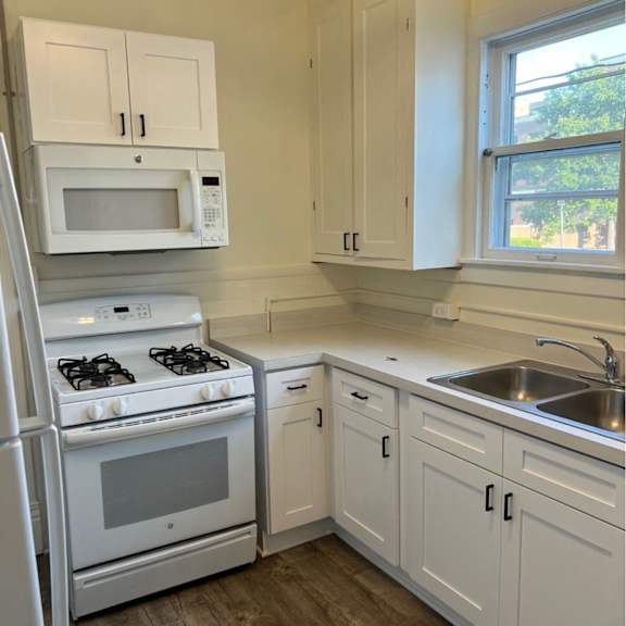 a kitchen with white appliances and cabinets.