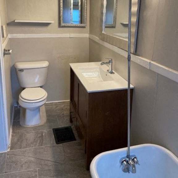 a bathroom with a toilet, sink, and mirror.