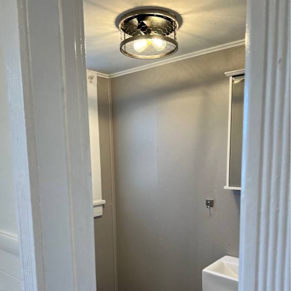 a small bathroom with a toilet, sink and mirror.