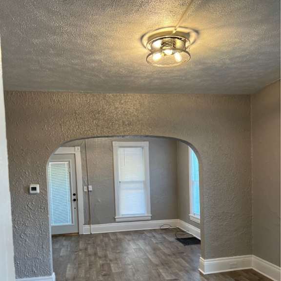 a room with a light on the ceiling and a doorway leading to another room.