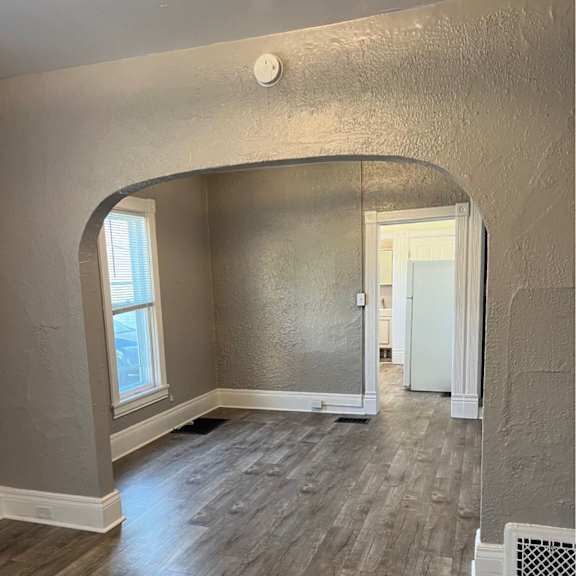 a room with wooden flooring and a white door.