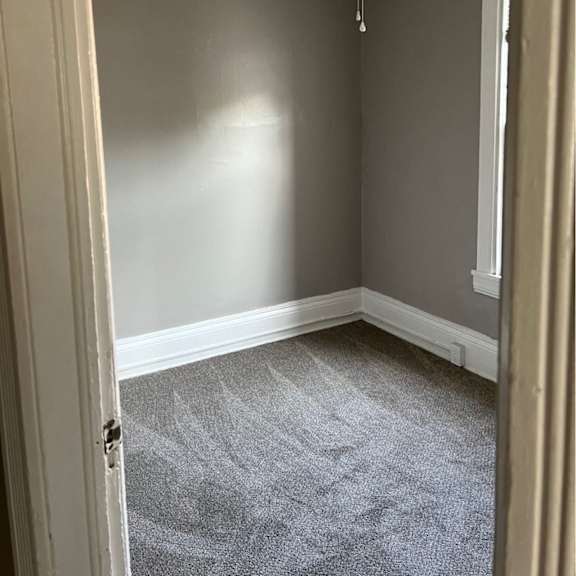 a room with a ceiling fan and carpeted floor.