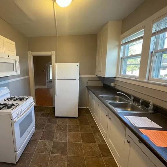 a kitchen with a white stove and a white refrigerator.
