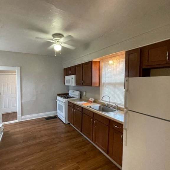 a kitchen with white appliances and wooden cabinets.