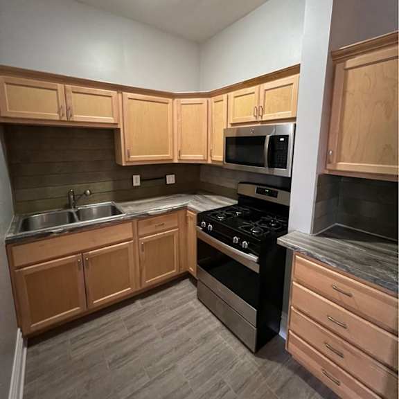 a kitchen with wooden cabinets and a black stove top oven.