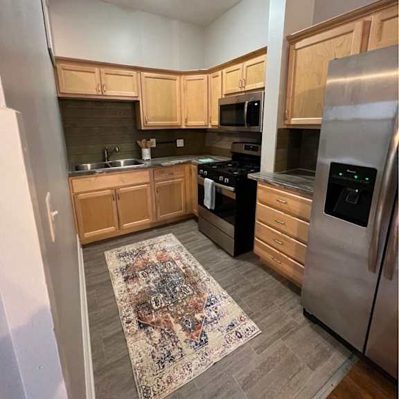 a kitchen with wooden cabinets and a rug on the floor.