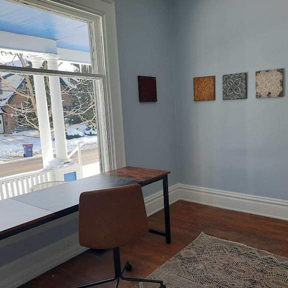 a brown chair sits in front of a desk with a window behind it.