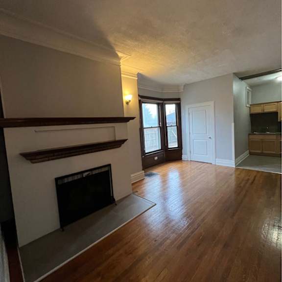 a room with a fireplace and wooden floors.