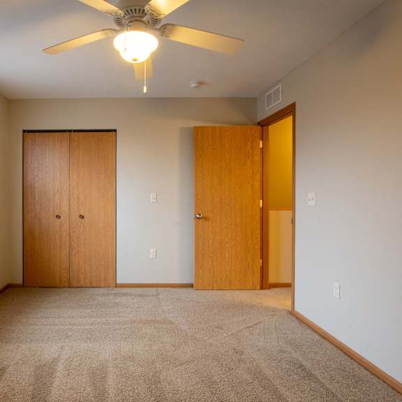 a room with a ceiling fan and two doors.