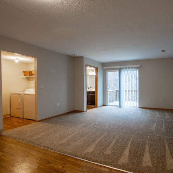 a room with a carpet on the floor and a door leading to a balcony.