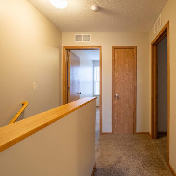 a room with a carpeted floor and a wooden door.