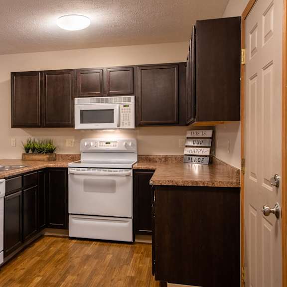 a kitchen with white appliances and brown cabinets.