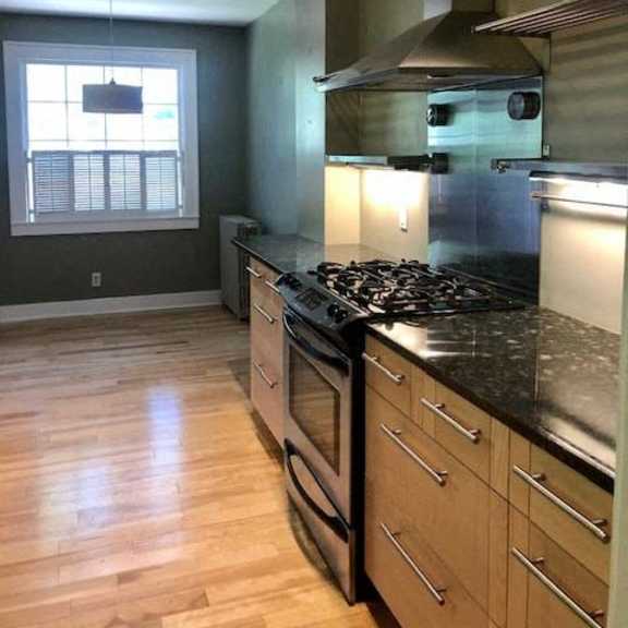 a kitchen with a black counter top and wooden cabinets.