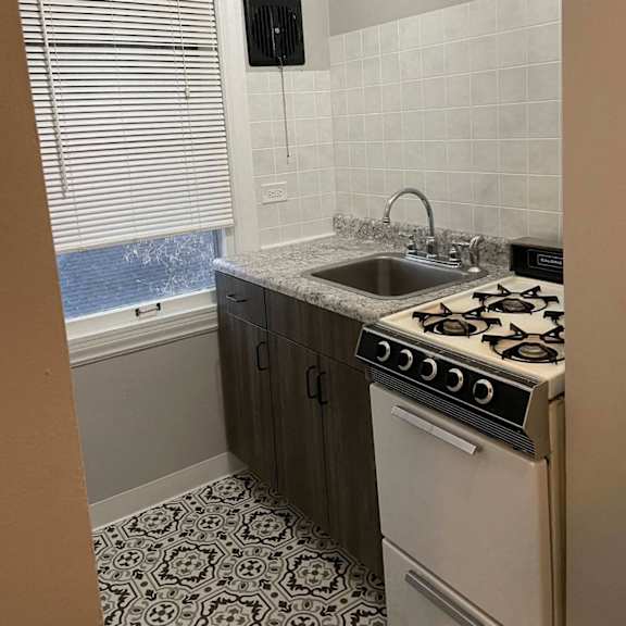 a kitchen with a stove top oven and a sink.
