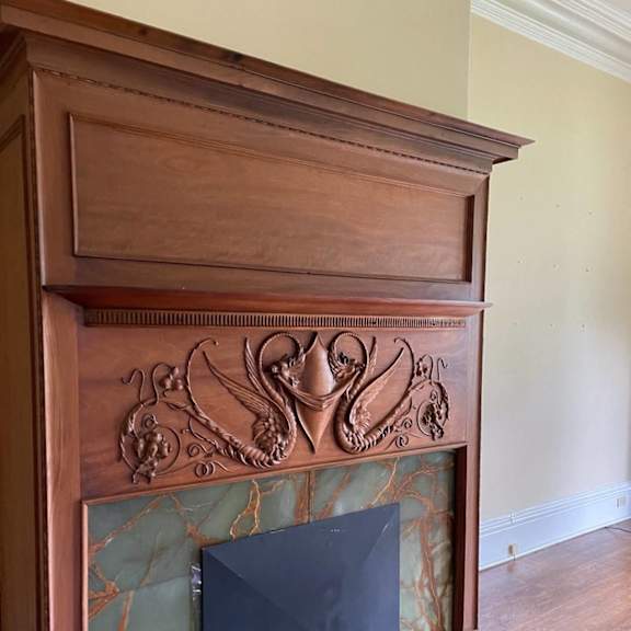 a fireplace with a wooden mantle and a green marble surround.