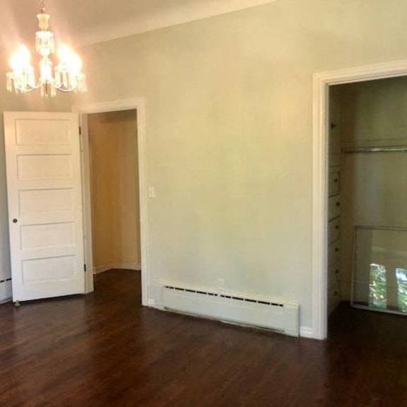 a room with a chandelier, a white door, and a window.