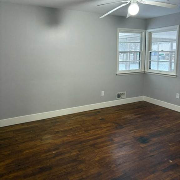 a room with a ceiling fan and wood flooring.
