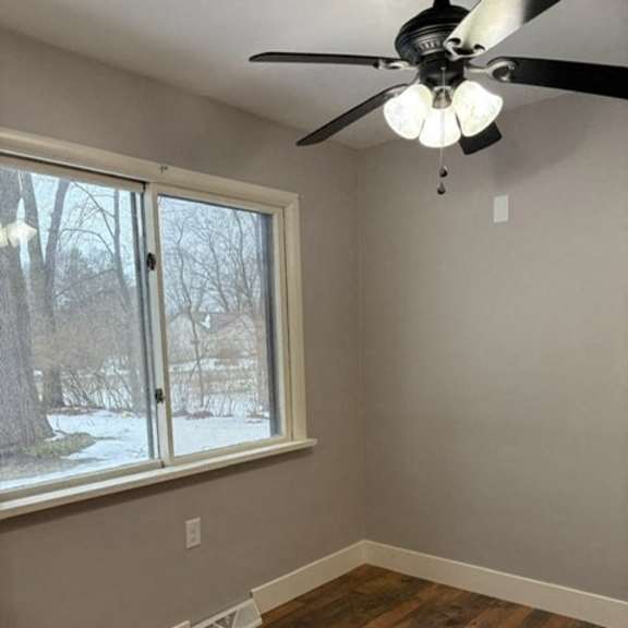 a room with a ceiling fan and a window.