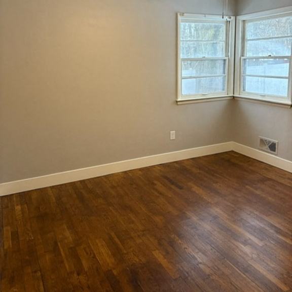 a room with a ceiling fan and wood flooring.