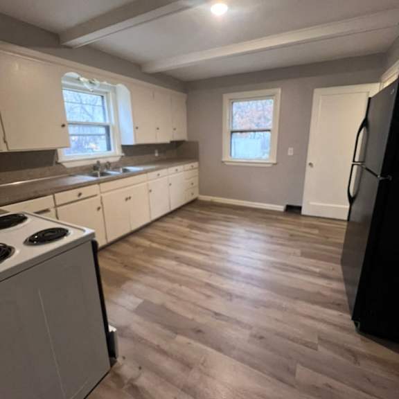 a kitchen with a black fridge and a white stove.